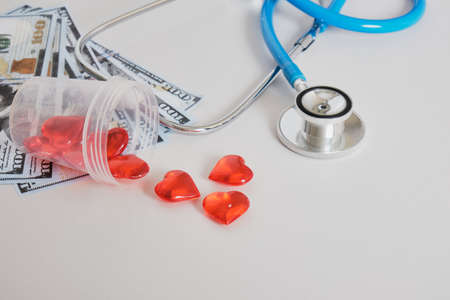 money, hearts in a jar for analyzes and a medical stethoscope on a gray background copy space, sperm and egg donation, artificial insemination and surrogacy concept, dollar billsの写真素材
