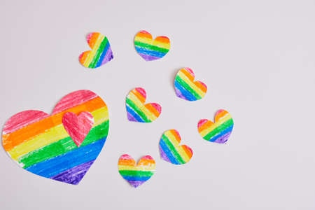homemade rainbow hearts on a gray background, drawn and cut hearts in the colors of the lgbt pride...
