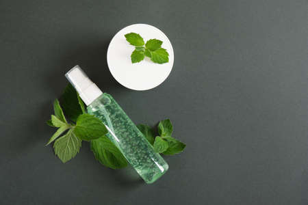 white cream jar, cosmetic bottle with green gel and fresh mint on dark green background. Organic cosmetics concept. Cosmetic mockup Natural skincare product .. Mint leaves, peppermint oil in cosmeticsの写真素材