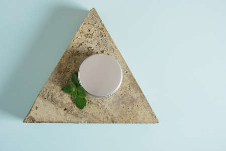 stone, cosmetic aluminum cream jar and fresh mint on green and blue background. Organic cosmetics concept. Cosmetic container mockup without label Natural skincare product.の写真素材