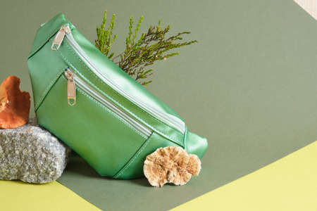 green belt bag made of eco leather on a stone, vegan leather from mushroom mycelium concept, leather from plants and mushrooms to replace animal leatherの写真素材