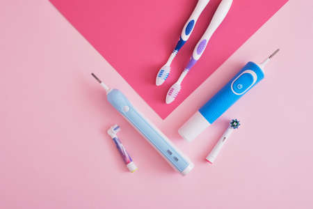 assorted toothbrushes on pink background, electric toothbrushes or plastic toothbrushes, which brushes are more efficient and more environmentally friendlyの写真素材