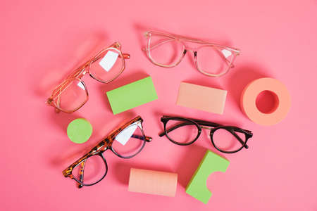 several different trendy eye glasses on geometric pink podiums, colorful background, copy space top viewの写真素材