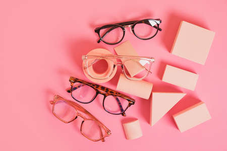 several different trendy eye glasses on geometric pink podiums, colorful background, copy space top viewの写真素材