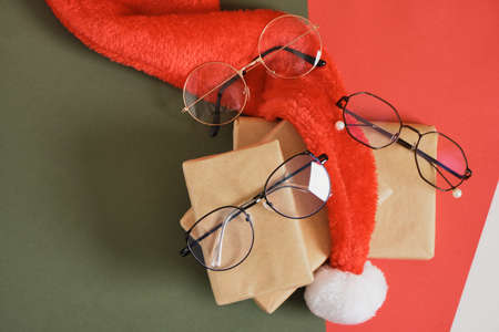 multiple eyeglasses and santa hat on red and green background, optics store sale before christmas, discounts and marketingの写真素材