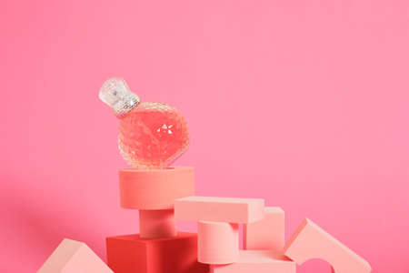 cristal glass perfume bottle and geometric podiums on pink background copy spaceの写真素材