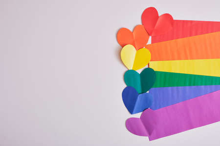 rainbow colored paper hearts and stripes of paper in the colors of the lgbt community flag on gray background, pride conceptの写真素材