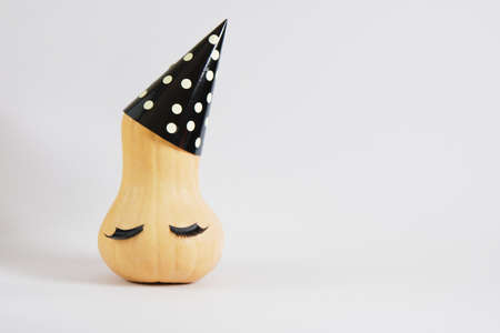 pumpkin in party hat on gray background copy space, new year or christmas minimal conceptの写真素材