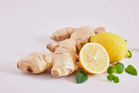 ginger root, mint leaves and lemons on a gray background, health benefits of ginger, natural drink for immunity copy spaceの写真素材