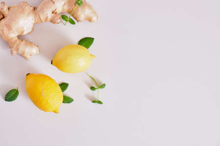 ginger root, mint leaves and lemons on a gray background, health benefits of ginger, natural drink for immunity copy spaceの写真素材