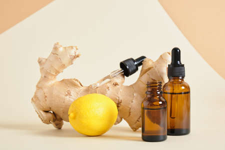 lemon, amber glass dropper bottles and ginger root on beige background copy space natural cosmetic concept, bottles with oil or serum, aroma therapyの写真素材