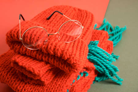 stylish eye glasses on a red knitted hat, christmas sale in the optics store, trendy eyeglass frames, festive atmosphere, Santa eye glassesの写真素材