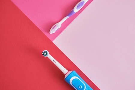 different toothbrushes on pink background, electric toothbrush or plastic toothbrush, environmental friendliness lifestyle concept, efficiency of brushing teethの写真素材