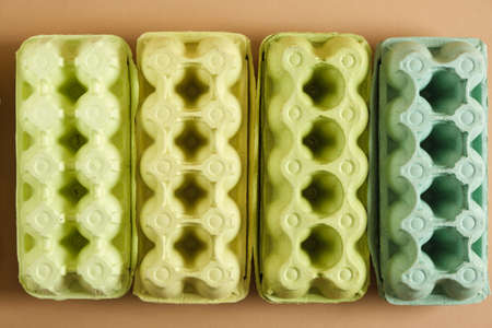 several cardboard egg boxes, waste recycling concept, waste sorting, green gradient from egg boxes