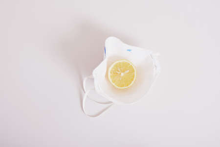 a creative concept, medical face protection mask and sliced lemon laid out in the form of fried eggsの写真素材