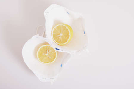 a creative concept, medical face protection mask and sliced lemon laid out in the form of fried eggs