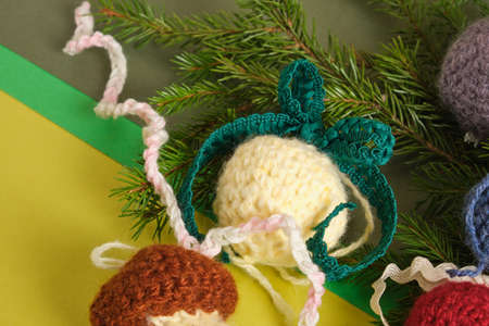 handmade. knitted balls for the Christmas tree, various crocheted Christmas toys, fir branches. green background, craft decorations, cozy decorの写真素材