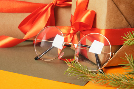 beatiful trendy eye glasses on gift box with red ribbon, Santa Claus eyeglasses and presentsの写真素材
