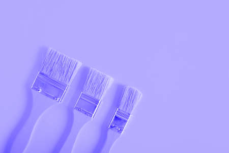 wooden yellow paint brushes on a yellow background copy space top viewの写真素材