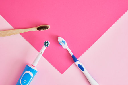 several different types of toothbrushes on a pink background, electric, bamboo and plastic toothbrushes, environmental friendliness lifestyle concept, plastic recyclingの写真素材