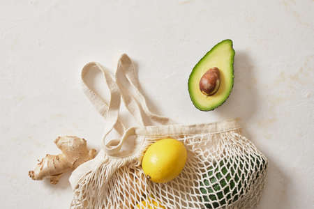 avocado, ginger and lemon with mesh shopping bag, top view, copy space, vegan lifestyle, natural cure for the common cold, healthy diet ingredients, say no to plasticの写真素材