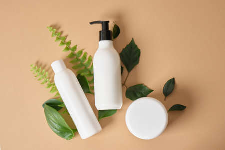 mock up organic cosmetic plastic bottles and jar with green leaves. natural cosmetic conceptの写真素材
