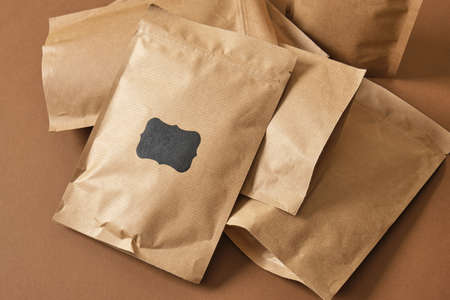 paper bags with black sticker for inscription on brown background Eco friendly packaging, paper recycling, zero waste, natural products concept. Copy space.の写真素材