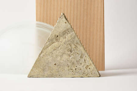 concrete tile in the shape of a triangle, beige corrugated cardboard and a glass arch on a light background, mock-up podiums for product presentation or advertisingの写真素材