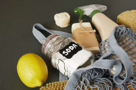 non-toxic home cleaning products in a knitted mesh bag, lemon, soda, spray bottle and cleaning tool...
