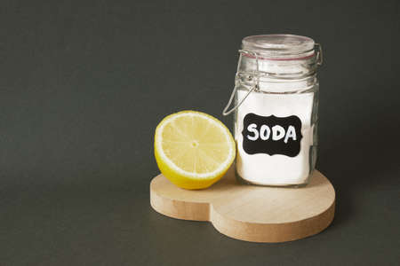 soda in a labeled jar and lemon on a heart-shaped wooden stand dark green background copy space eco...