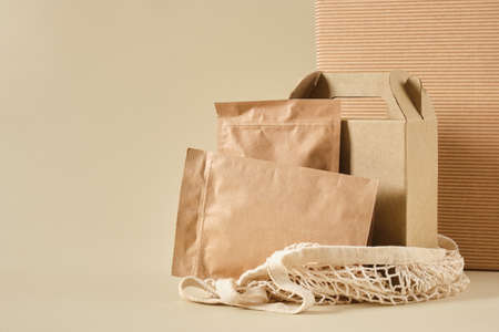 box and paper zip bags in a mesh bag for shopping, beige background top view, mock-up packaging for products, packages for delivery, eco-friendly natural materials, CO2 neutralの写真素材