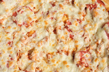 Pizza background - macro shot of pizza, close up pizza with cheese and sausageの写真素材
