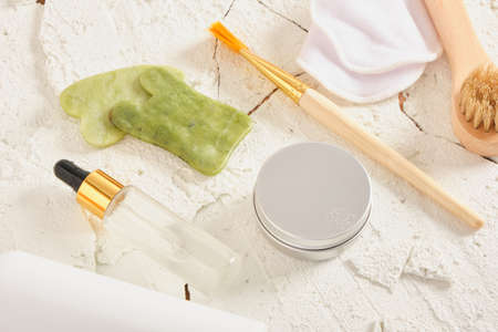 set for the care of dry and tired skin on a cracked white natural background, a cosmetic mask, brush...