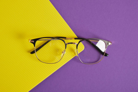 trendy eye glasses on a purple and yellow background glasses for study, computer work and reading,...