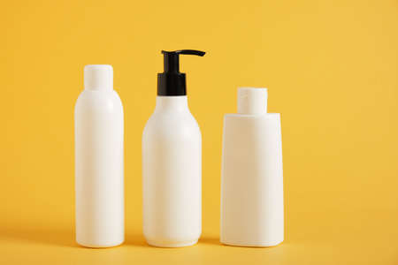 different mockup blank bottles for cosmetics on a yellow background, natural cosmetics concept,...