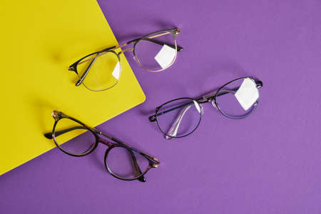 trendy eye glasses on a purple and yellow background glasses for study, computer work and reading, fashionable eyeglass framesの写真素材