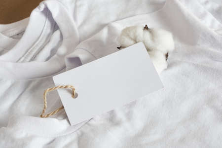 white chlidren t-shirts and blamk white tag, cotton flower and clothes mock up, slow fashion, cotton material, eco friendly lifestyleの写真素材