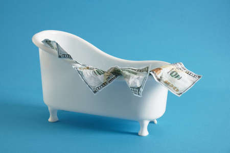 100 dollar bills in a small tub on a snowy background, foam on money, money laundering, tax evasion...