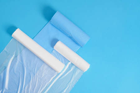 different plastic polyethylene trash bag rolls on blue background top view copy spaceの写真素材