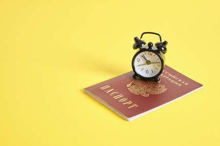 passport of a citizen of Russia and an alarm clock, countdown, change of events, travel and education conceptの写真素材