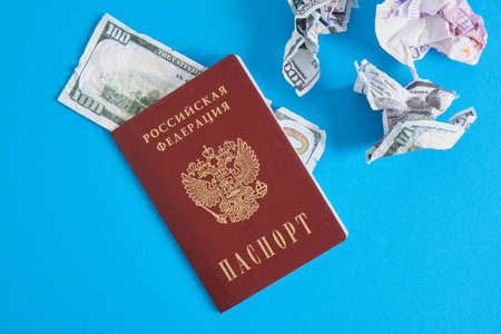 passport of a citizen of the Russian Federation and crumpled dollar and euro bills, bipolarity of the world concept, change of world currencyの写真素材