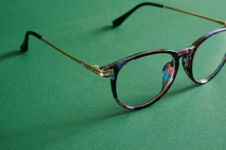 trendy modern eye glasses on green background copy space close upの写真素材