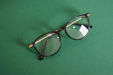 trendy modern eye glasses on green background copy space close upの写真素材