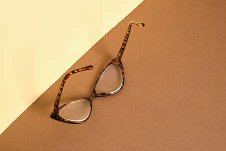 trendy fashion eye glasses on creative paper brown and beige background, vision conceptの写真素材