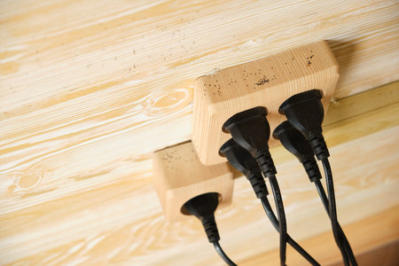 electric sockets made of natural wood, safe sockets, environmentally friendly materials, wooden walls on the background, plugs and wiresの写真素材