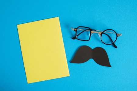 happy father's day concept, postcard and envelope mocap on blue background, mustache, glasses, flat lay top viewの写真素材