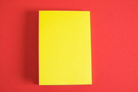 Design concept - Top view of yellow notebook and pen collection isolated on red background for mockup copy spaceの写真素材