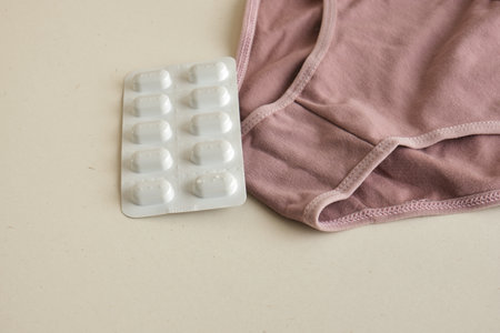 menstruation concept, women's health care and contraception, pills and women's panties on a light...