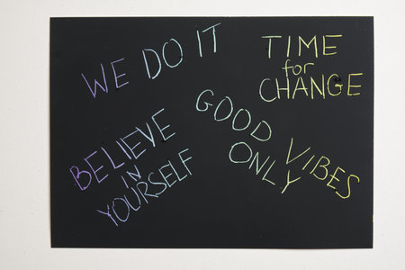 different colored motivational slogans are scratched on on a black engraving board
