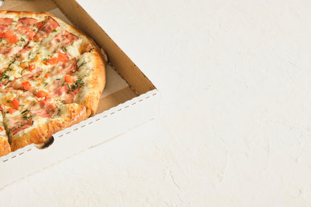 pizza with tomatoes and cheese in box for delivery on gray background copy space close upの写真素材